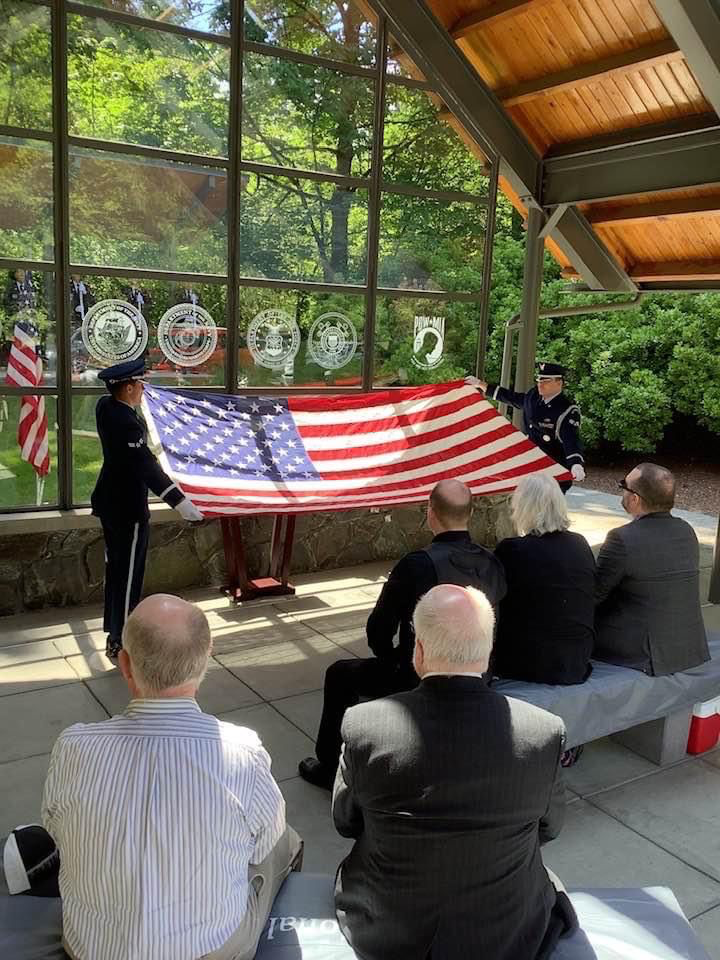 McChord Field honor guard members fold a flag over a casket during a funeral